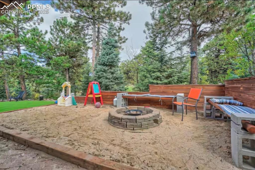 View of patio featuring an outdoor fire pit and a playground