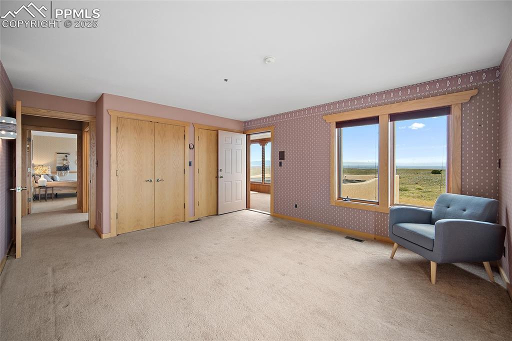 Living area featuring wallpapered walls and carpet floors