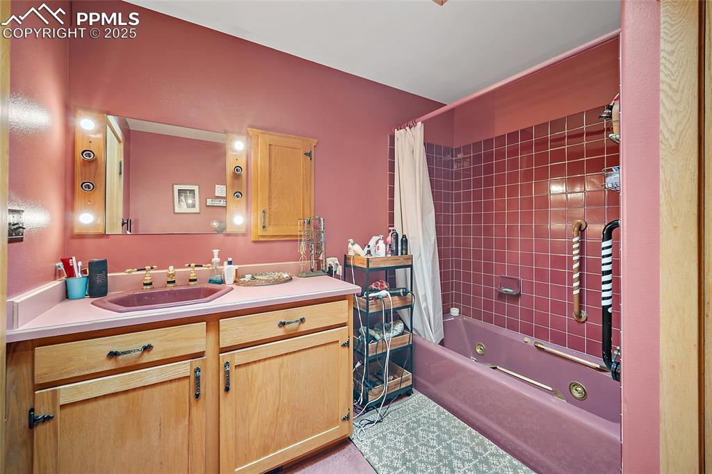 Full bathroom with shower / bath combo with shower curtain and vanity