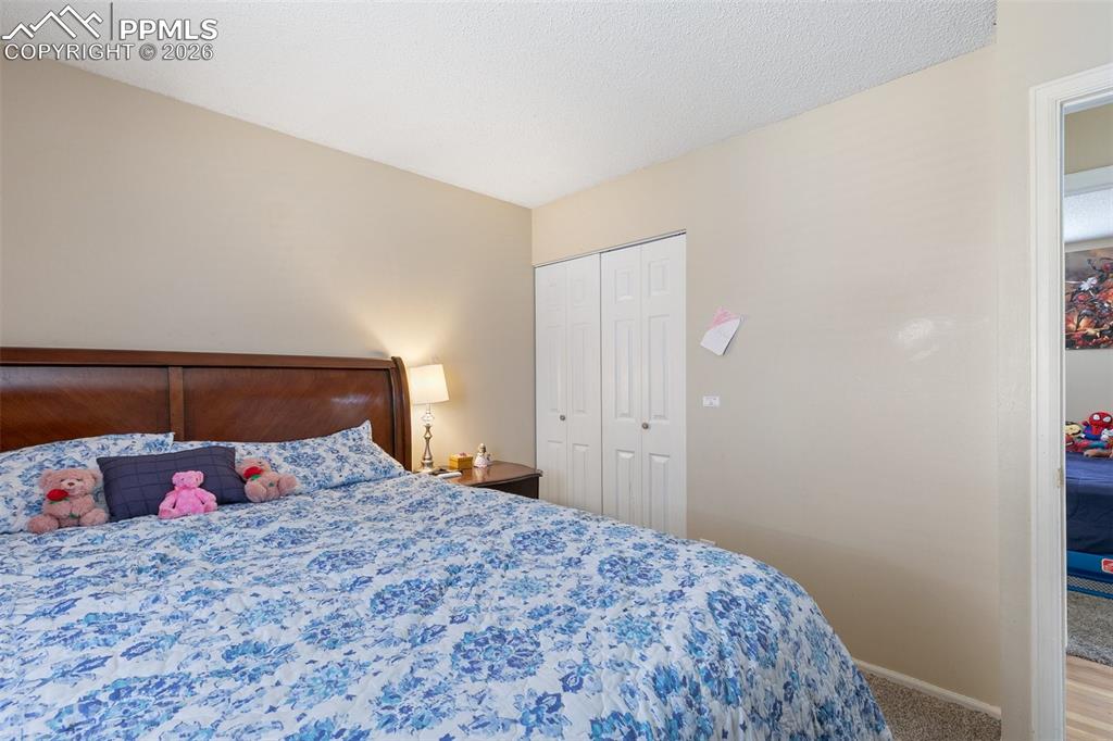 Carpeted bedroom with a closet and a textured ceiling