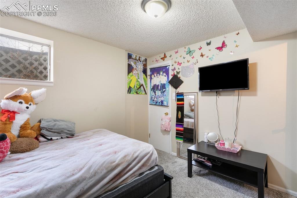 Carpeted bedroom featuring a textured ceiling