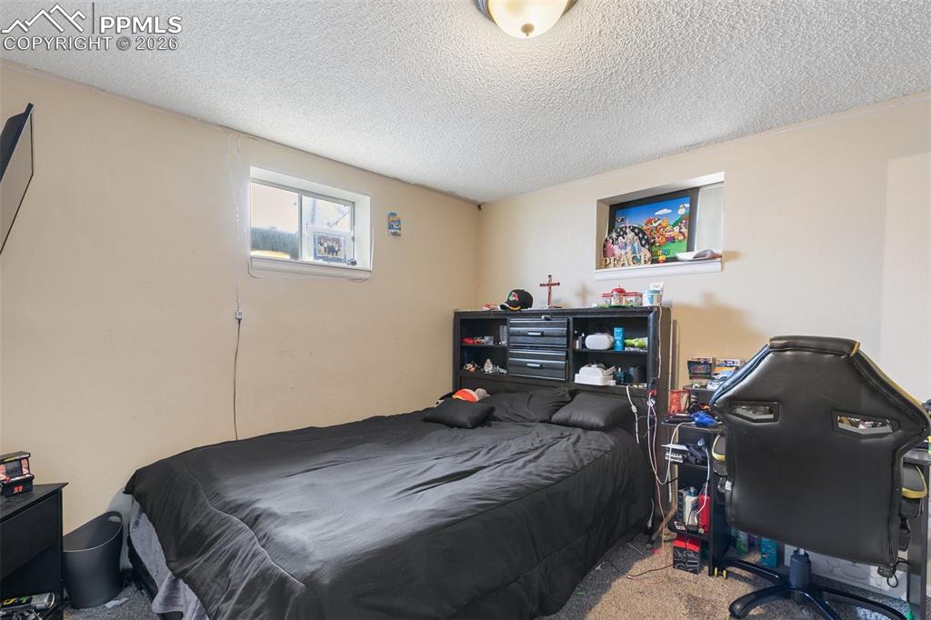Bedroom featuring a textured ceiling and carpet