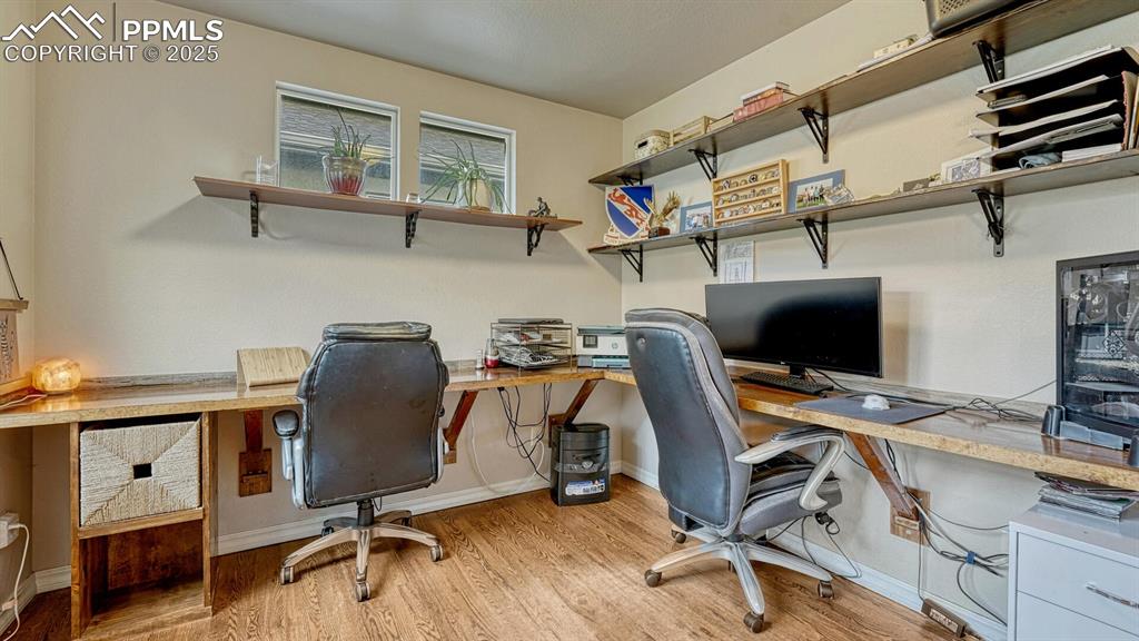 Office featuring light wood finished floors and built in desk