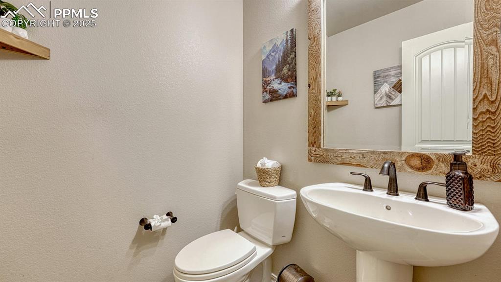 Half bath featuring toilet and a textured wall