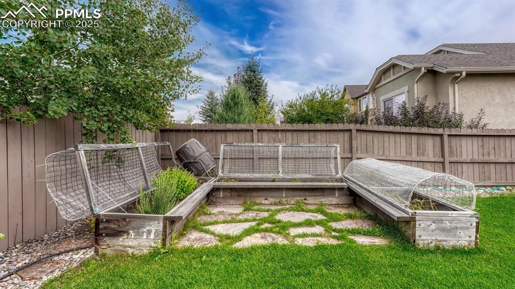 Fenced backyard with a vegetable garden