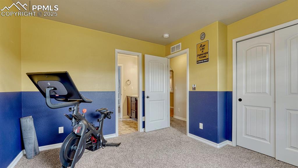 Workout room with carpet floors and baseboards