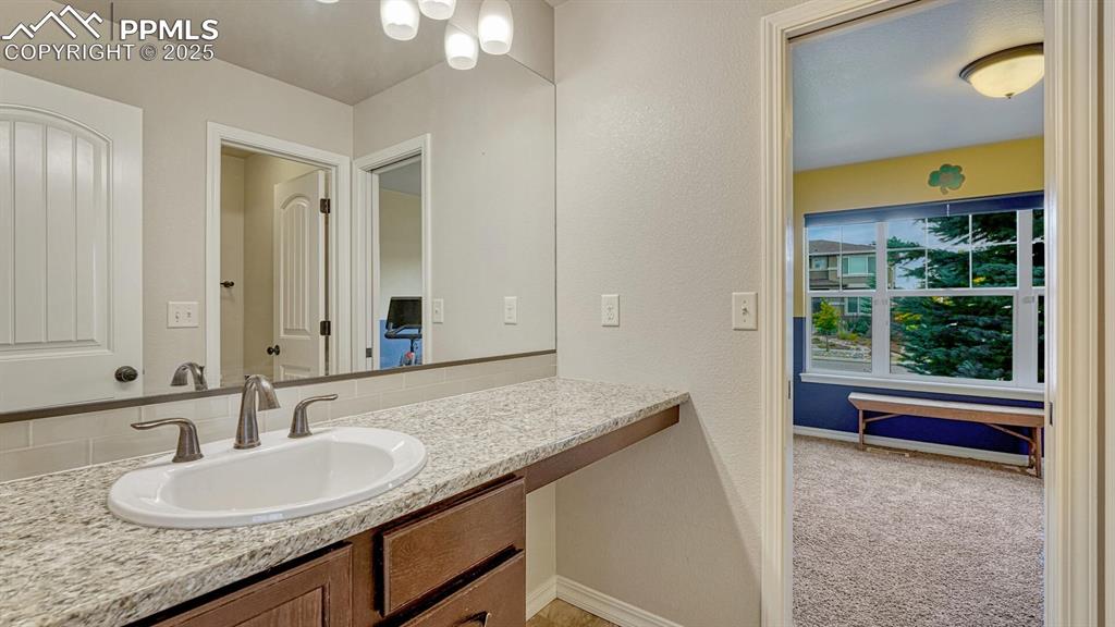 Bathroom featuring vanity and a textured wall