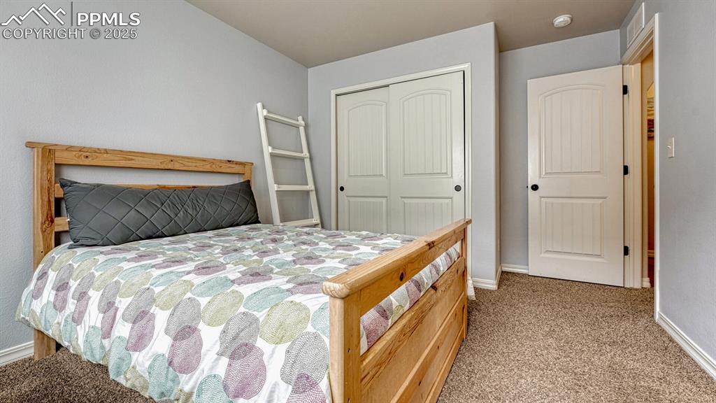 Bedroom with light carpet and a closet