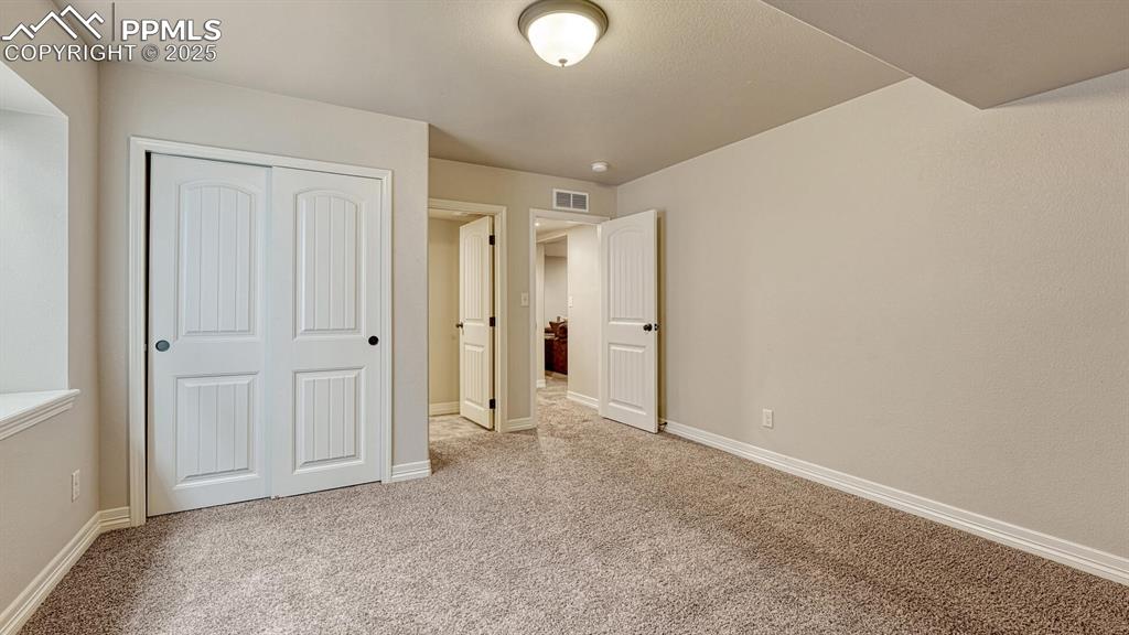 Unfurnished bedroom featuring light colored carpet and a closet
