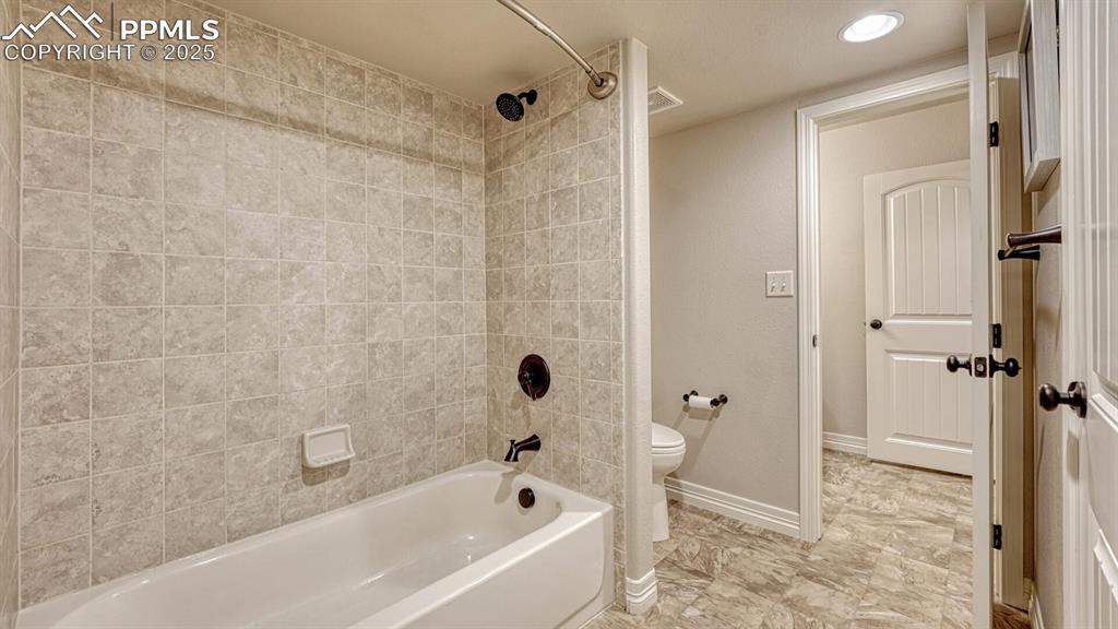 Bathroom with shower / washtub combination and recessed lighting