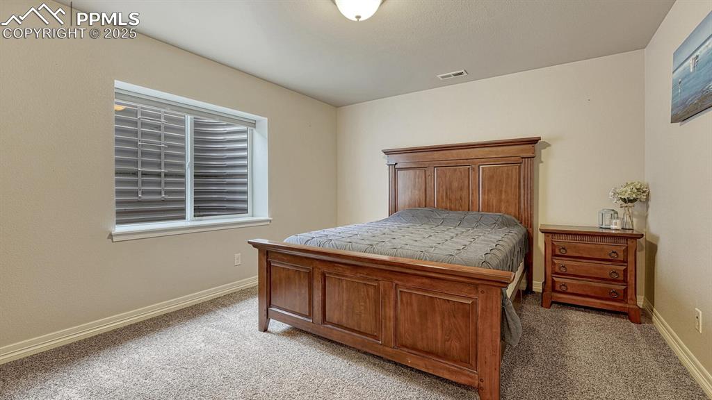 Bedroom with baseboards and light colored carpet
