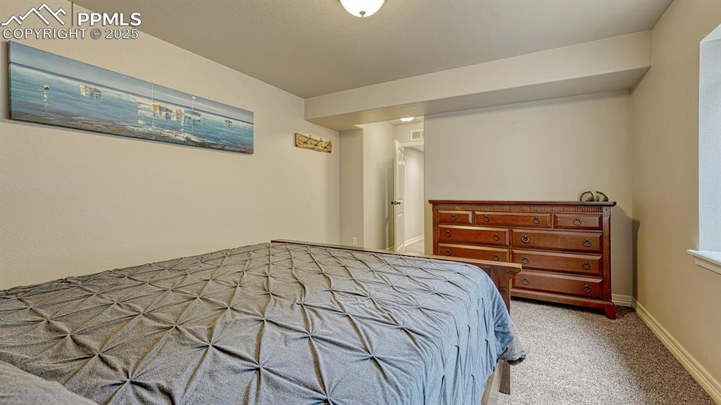 Bedroom with light carpet and baseboards
