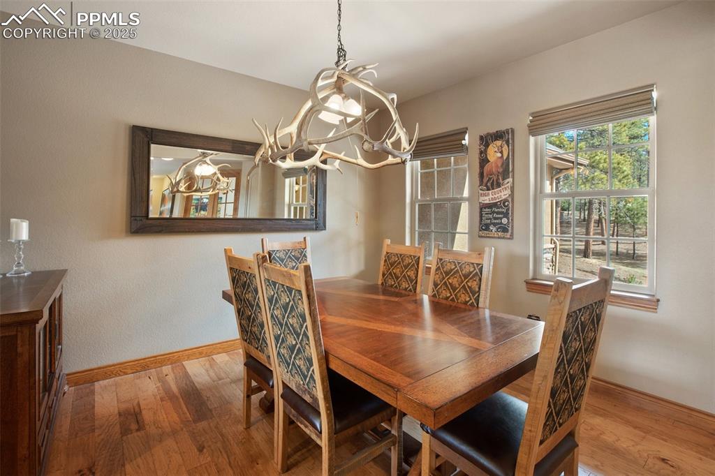 Dining area with wood finished floors, baseboards, and a chandelier
