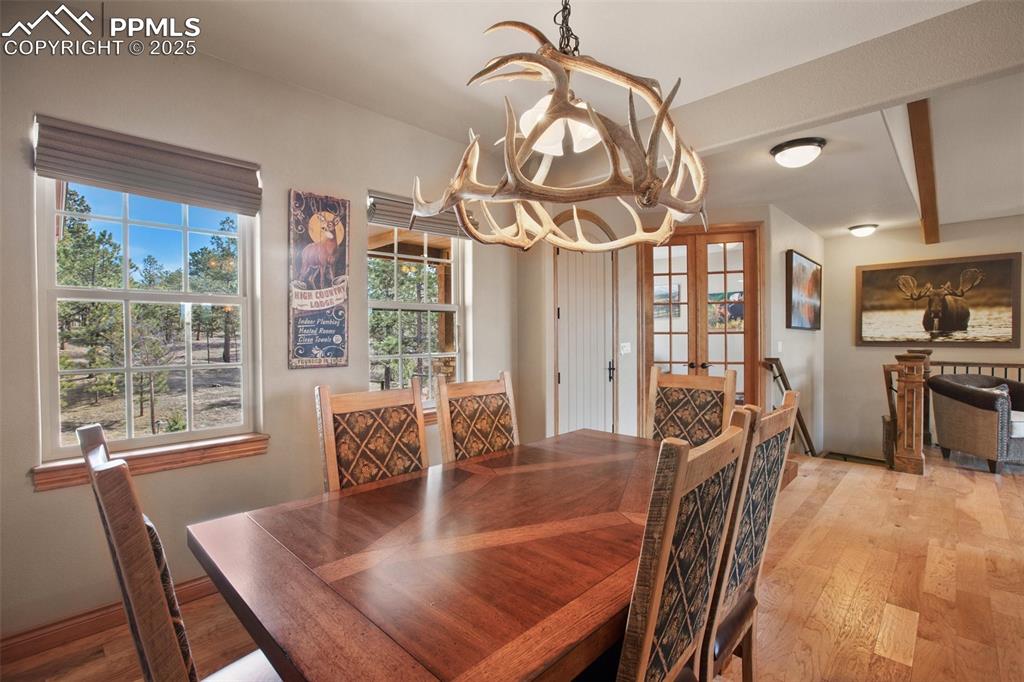 Dining area with a notable chandelier, french doors, and light wood-type flooring