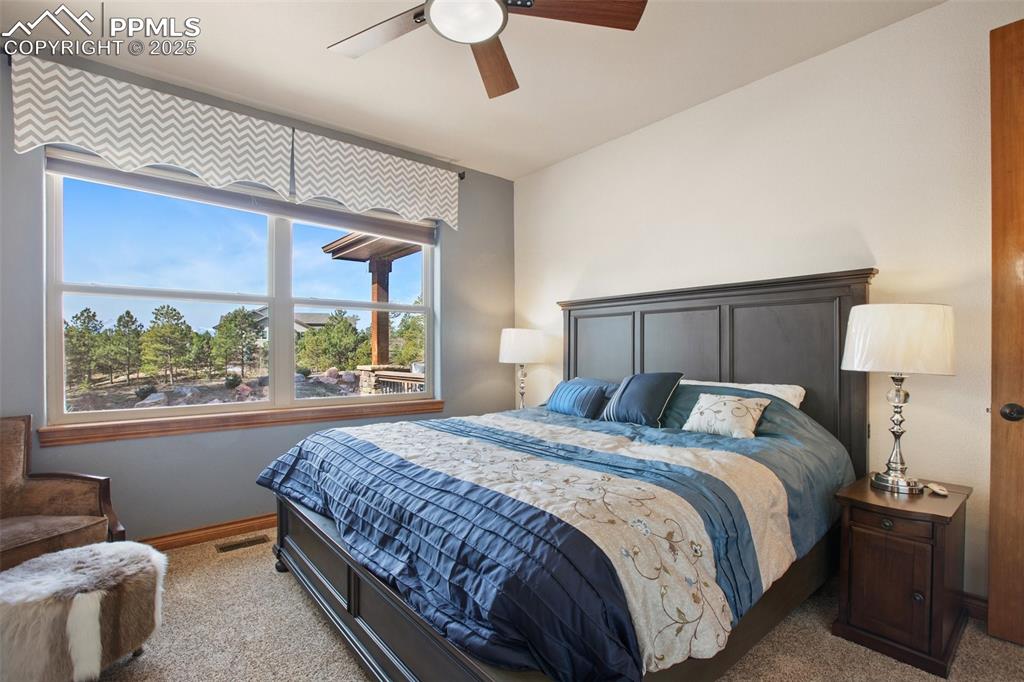 Bedroom featuring carpet flooring, visible vents, baseboards, and ceiling fan
