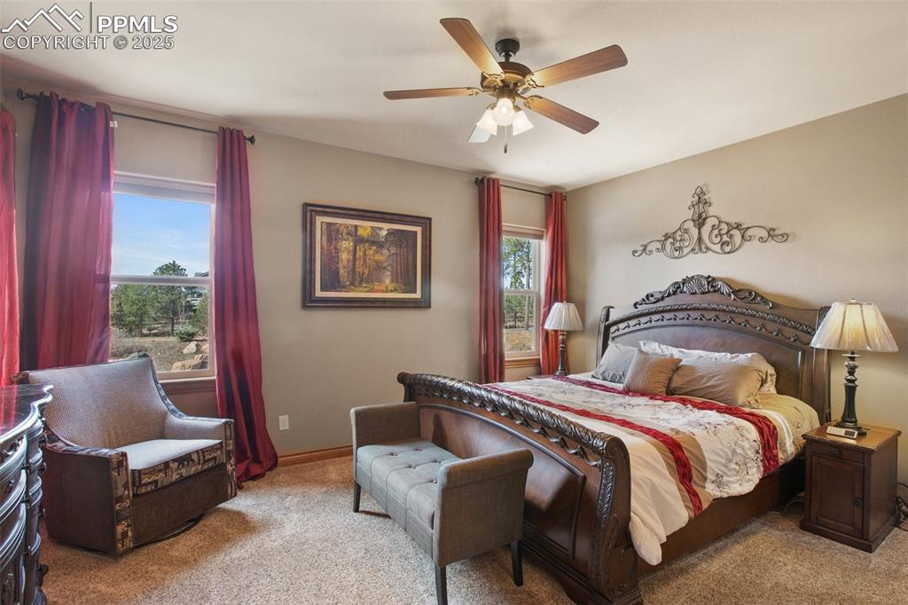 Carpeted bedroom with baseboards and ceiling fan