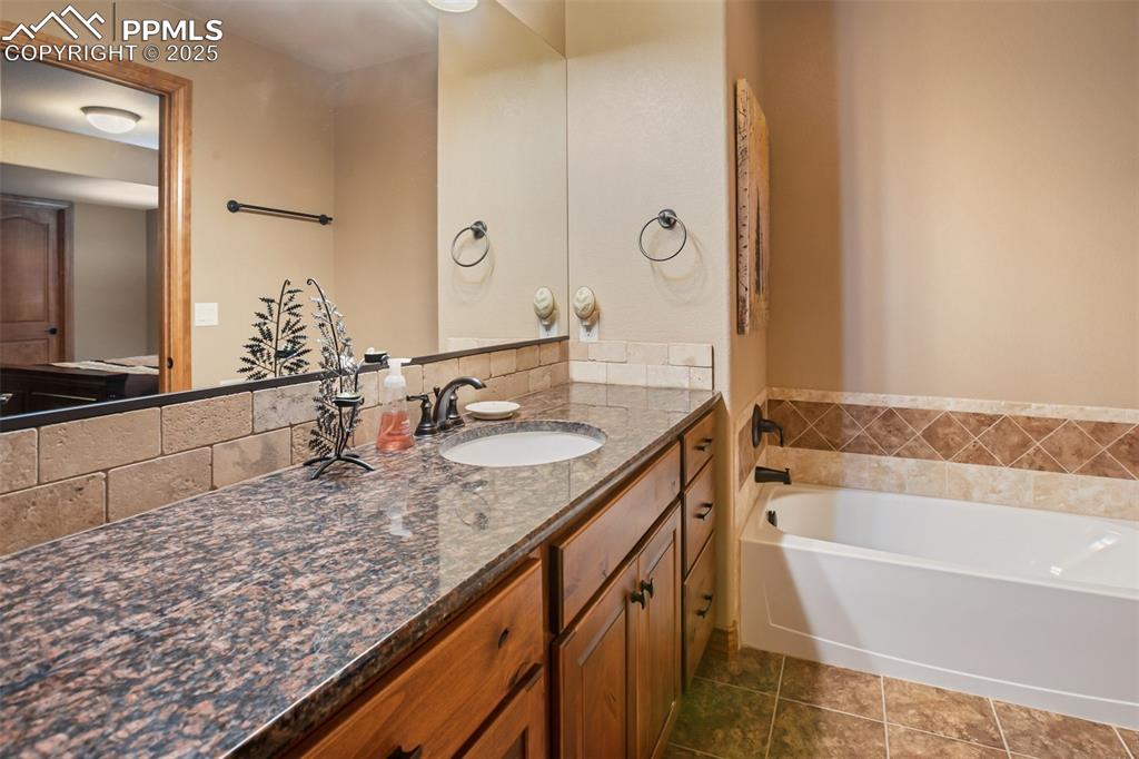 Full bathroom with a garden tub, vanity, and tile patterned flooring