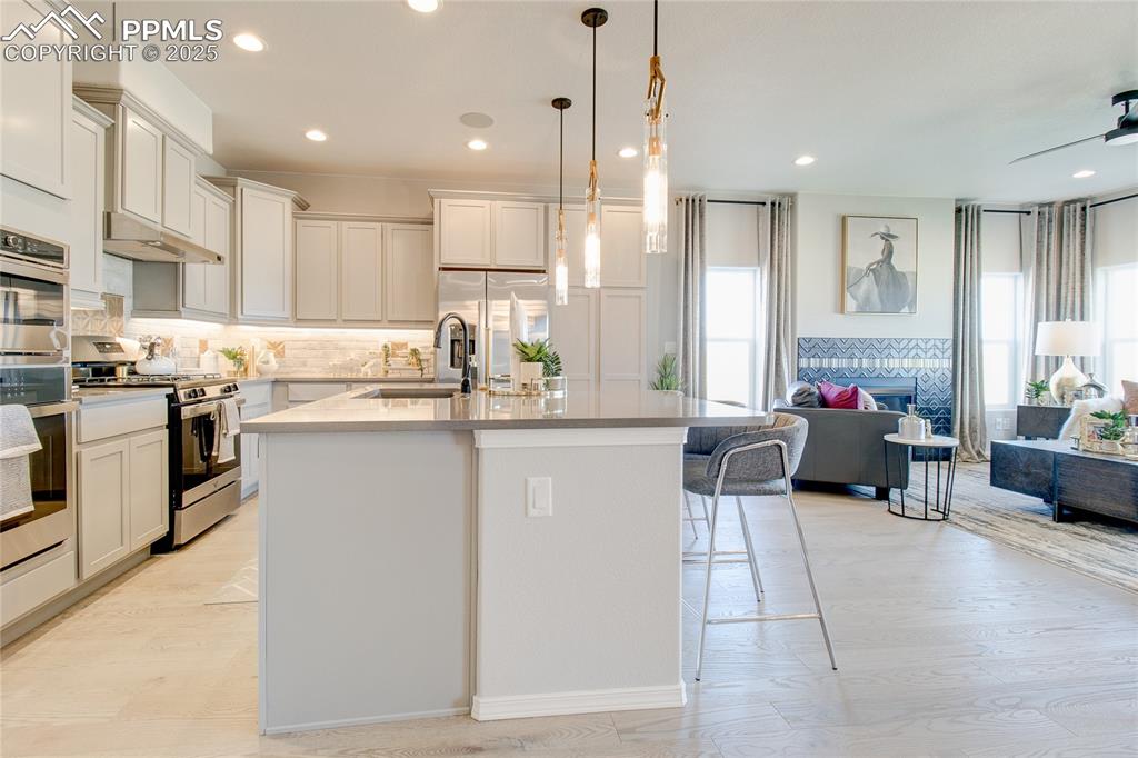 Kitchen with appliances with stainless steel finishes, plenty of natural light, open floor plan, a kitchen island with sink, and recessed lighting