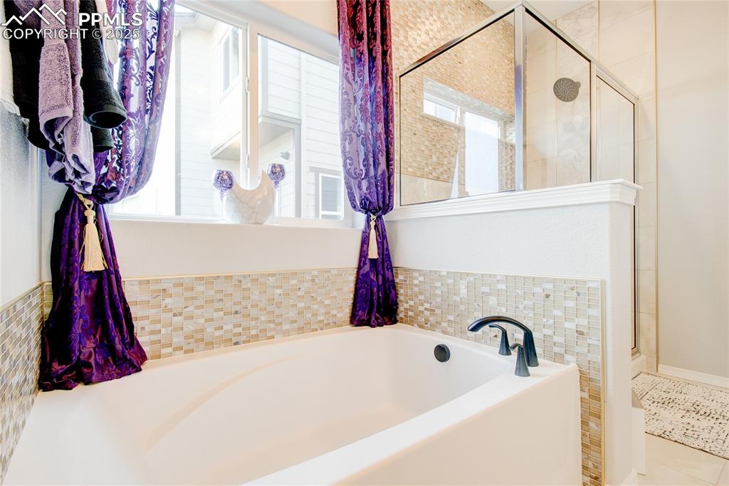Full bathroom with a shower stall, a garden tub, and tile patterned floors