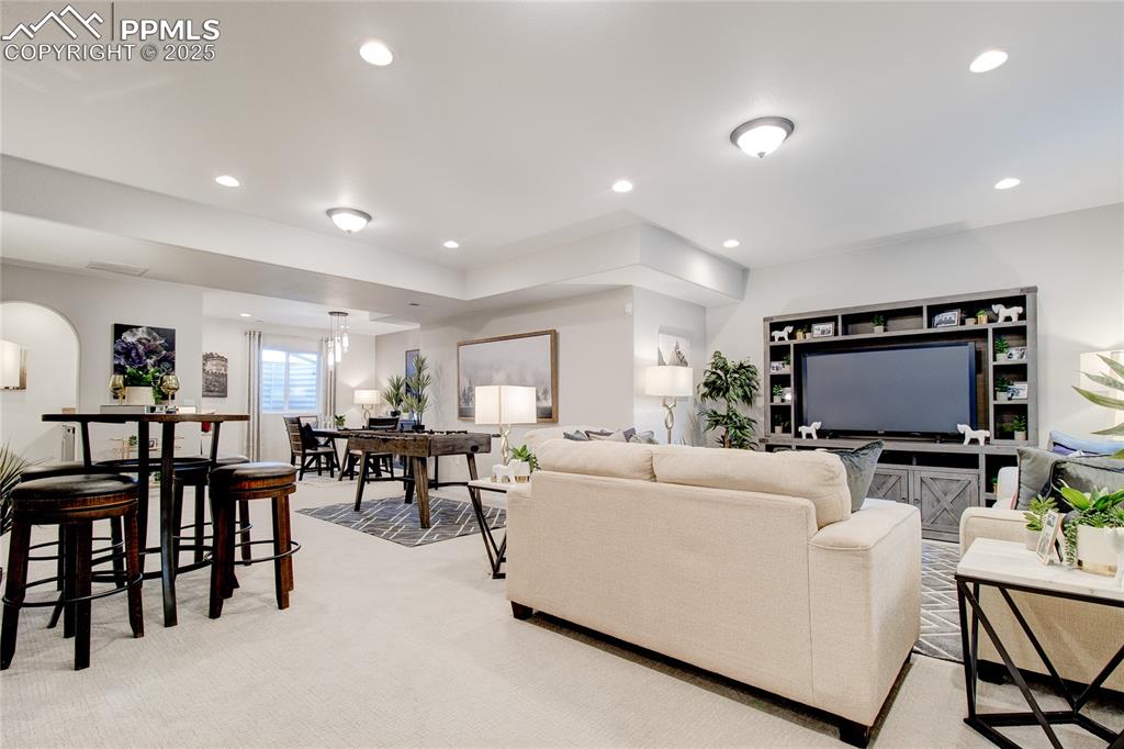 Living area with recessed lighting and light colored carpet