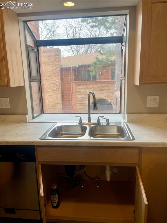 Kitchen has light countertops, stainless steel dishwasher, LOTS of natural light.