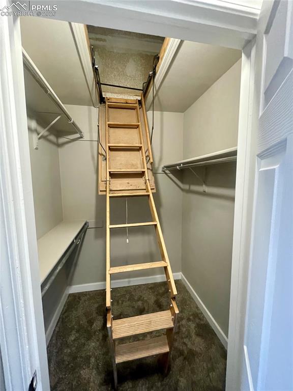 Large walk-in closet has attic access with lots more storage.