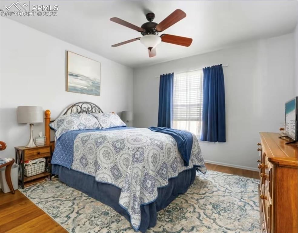 Bedroom featuring wood finished floors and a ceiling fan