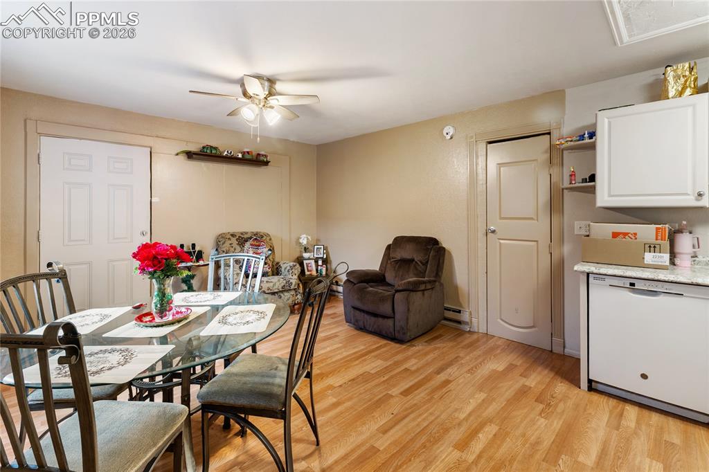Dining space featuring light wood-style floors, a ceiling fan, overlooking the living area!