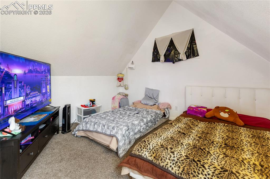 The main bedroom with carpet floors and lofted ceiling!