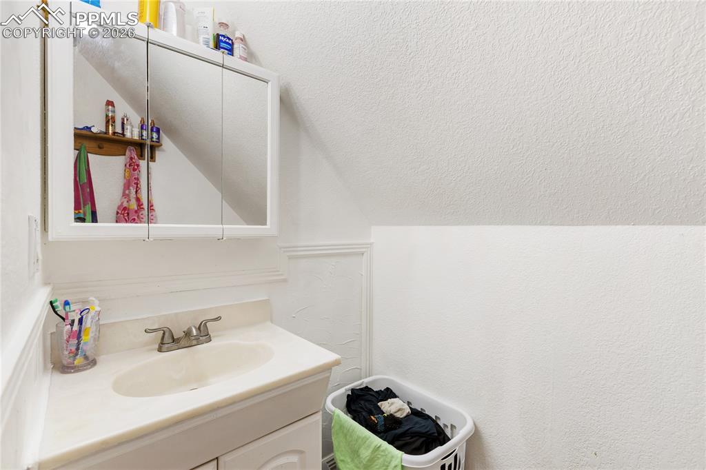 Bathroom with vanity and a textured wall
