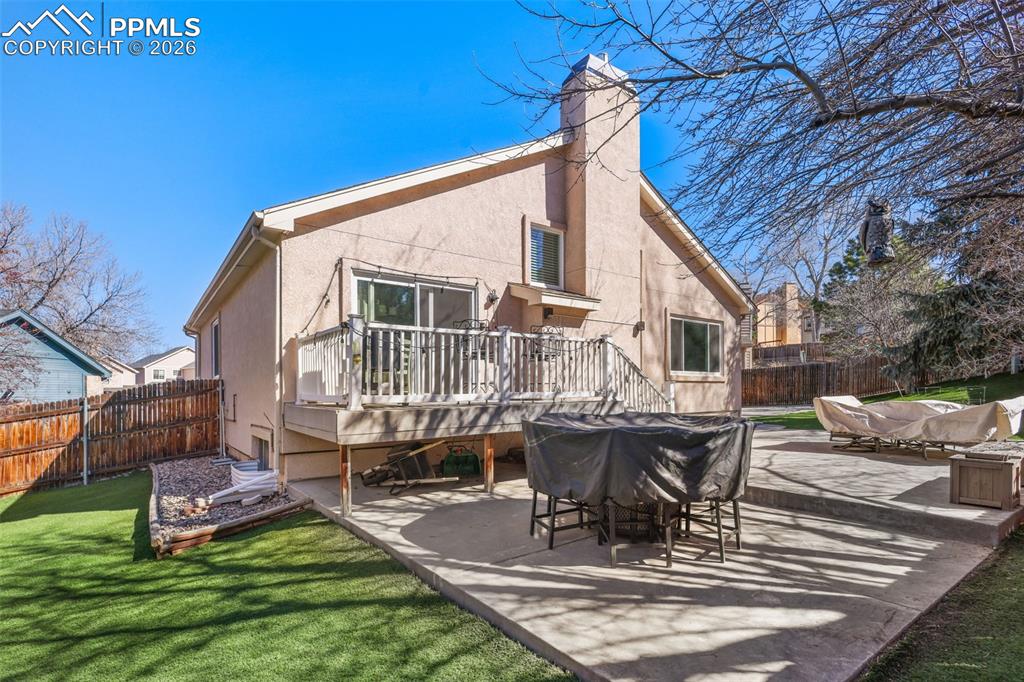 Back of house featuring Astroturf, deck and private backyard