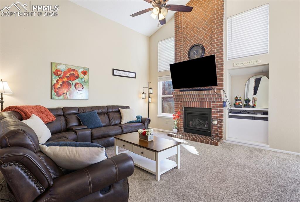 Family room featuring brick fireplace and vaulted ceiling