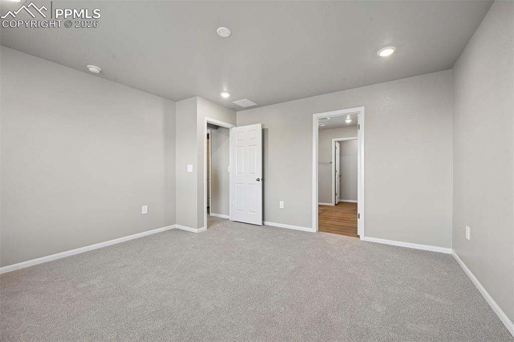 Unstaged primary bedroom w/ ensuite 