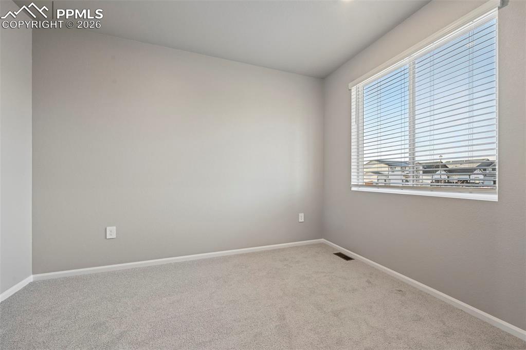 Unstaged flex room serves as dedicated office, formal dining room, or additional bedroom on main floor.