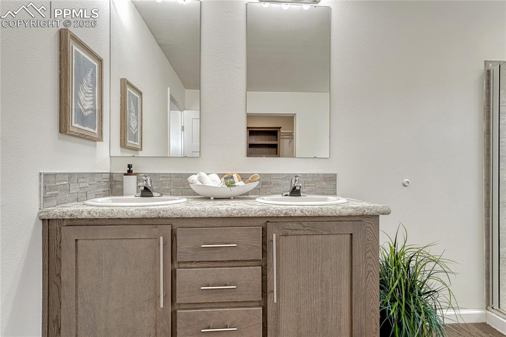 Each vanity has its own mirror and lighting with matching countertop and backsplash finishes.
