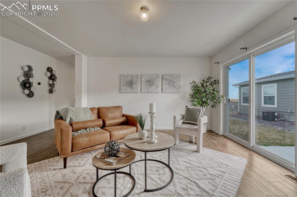 The living space offers a sliding glass door that walks out onto the patio and grass side/back yard space
