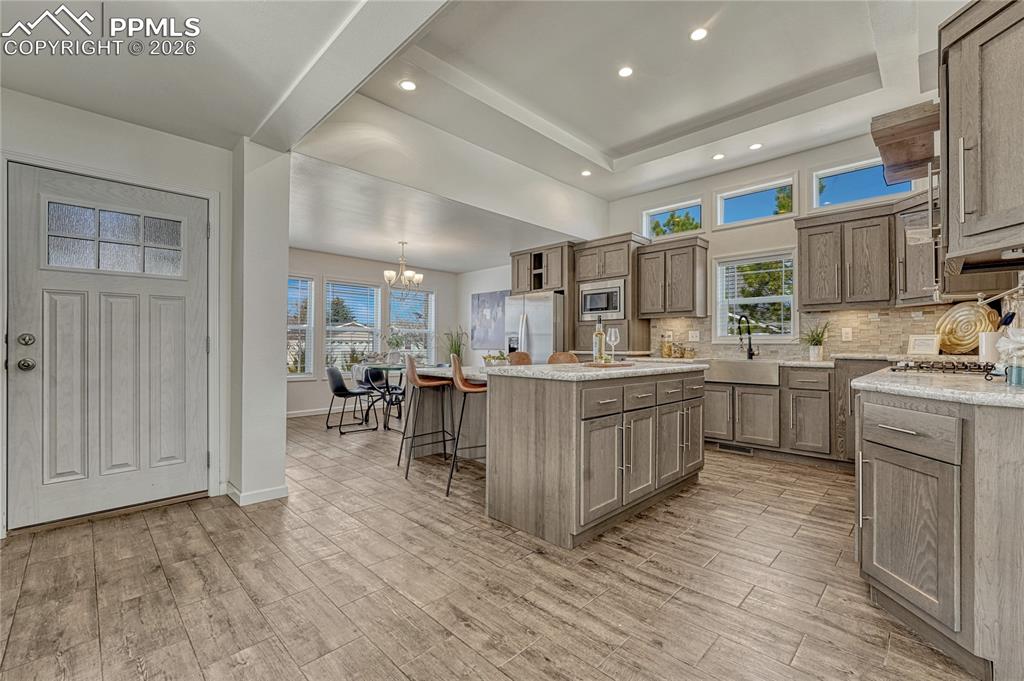 Off the entry is the spacious kitchen and dining space with tall ceilings and a tiered island
