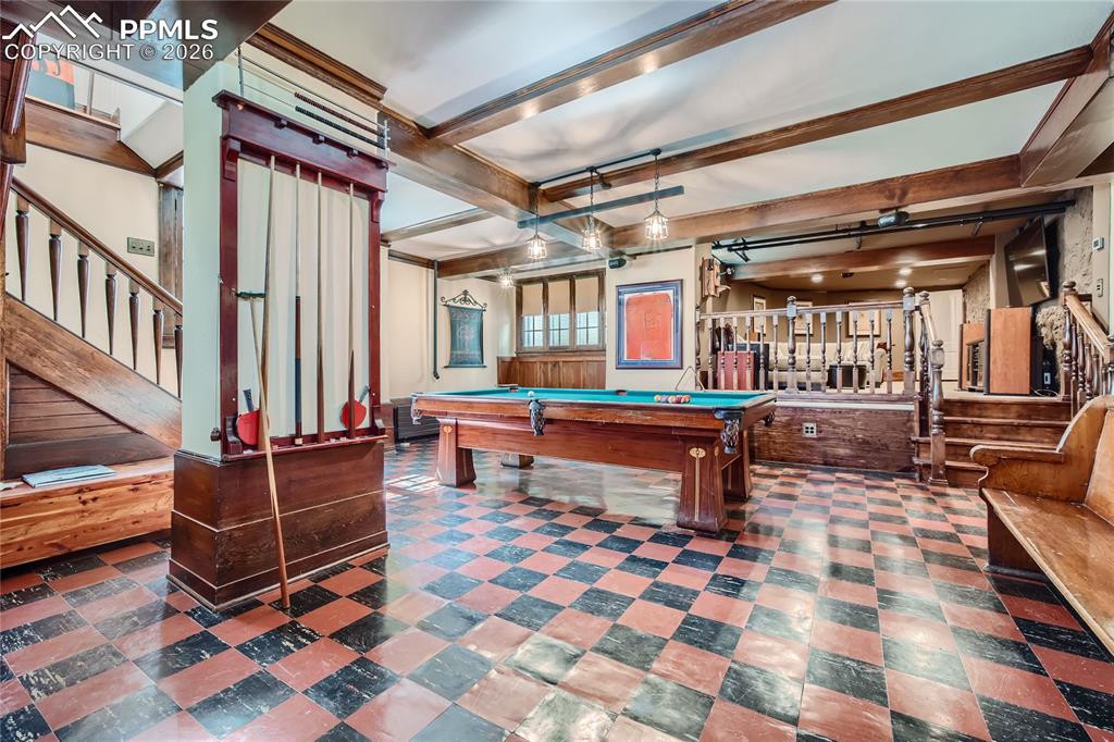 Playroom featuring beam ceiling, pool table, and dark tile floors