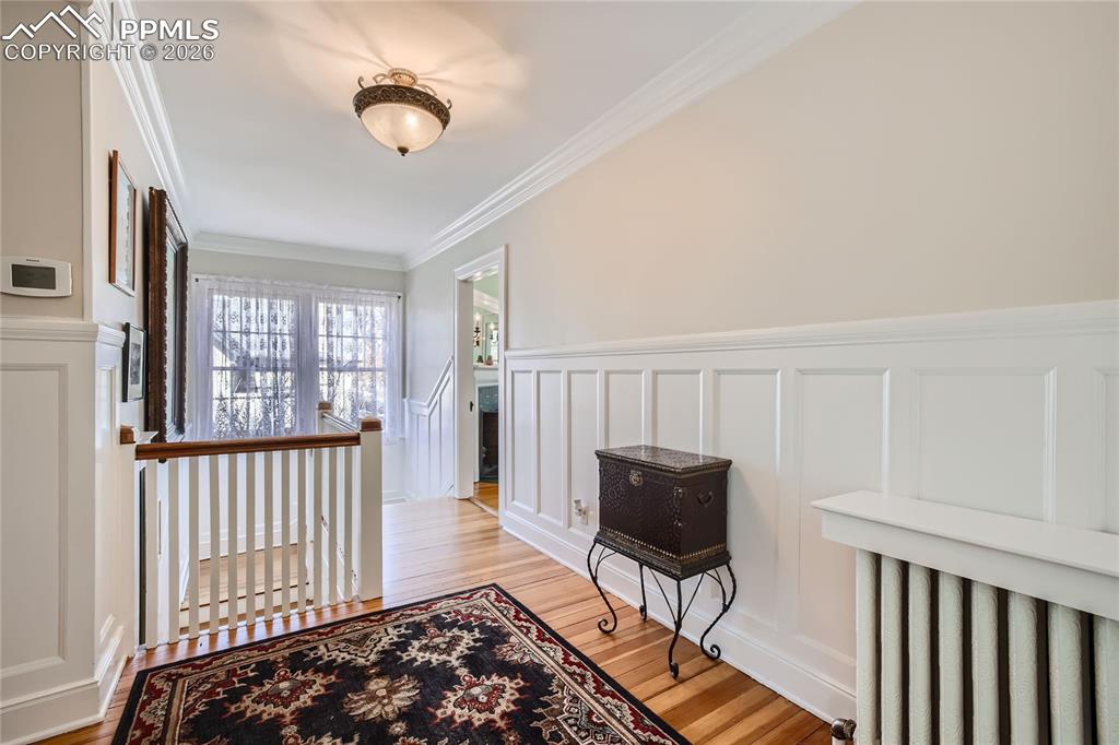 Hallway featuring ornamental molding and light hardwood floors