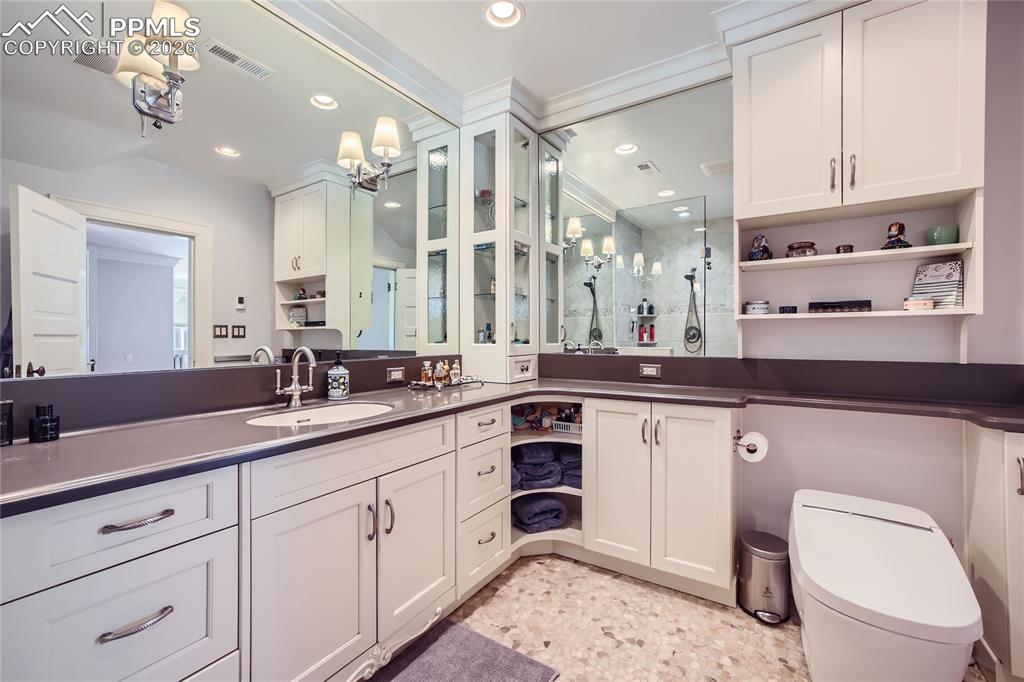 Bathroom with a toilet, vanity with extensive cabinet space, and tile floors