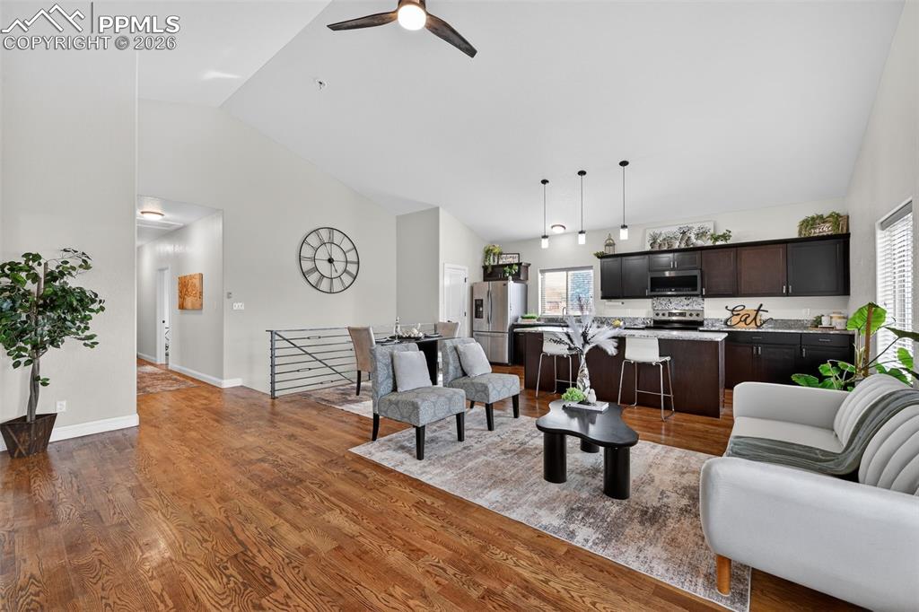 Entry into living room, open floor plan, with beautiful hardwood floors and vaulted ceilings.