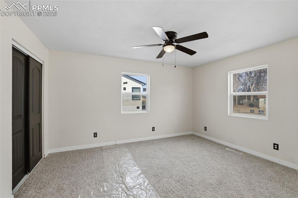 Unfurnished bedroom with carpet floors, a closet, and a ceiling fan
