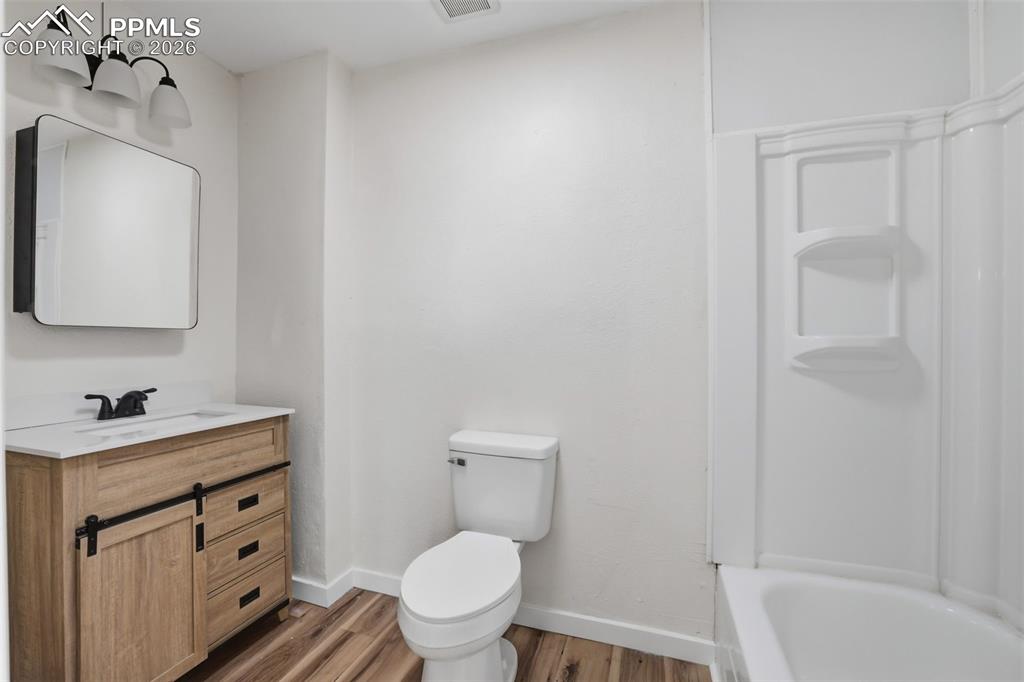 Full bathroom with vanity, light wood finished floors, and shower / bath combination