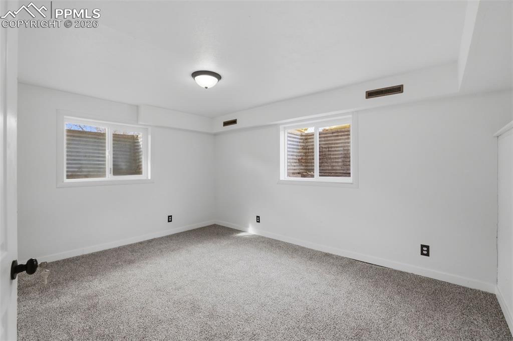 Carpeted empty room with baseboards