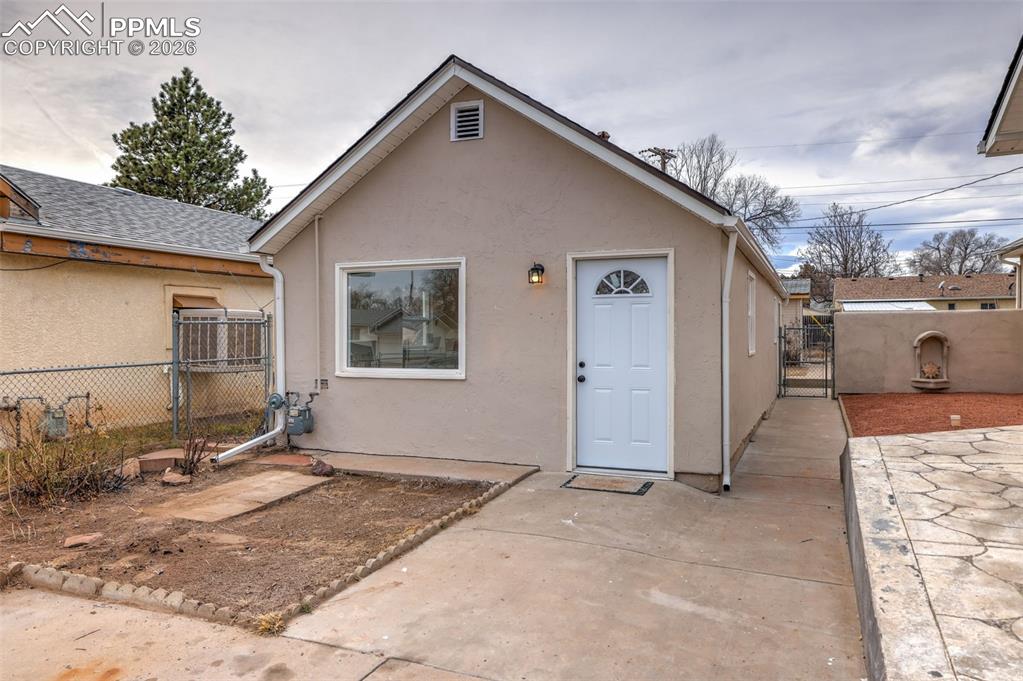 View of front of property with a gate and stucco siding