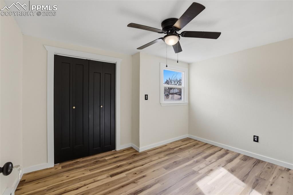 Unfurnished bedroom featuring a closet, light wood finished floors, and ceiling fan