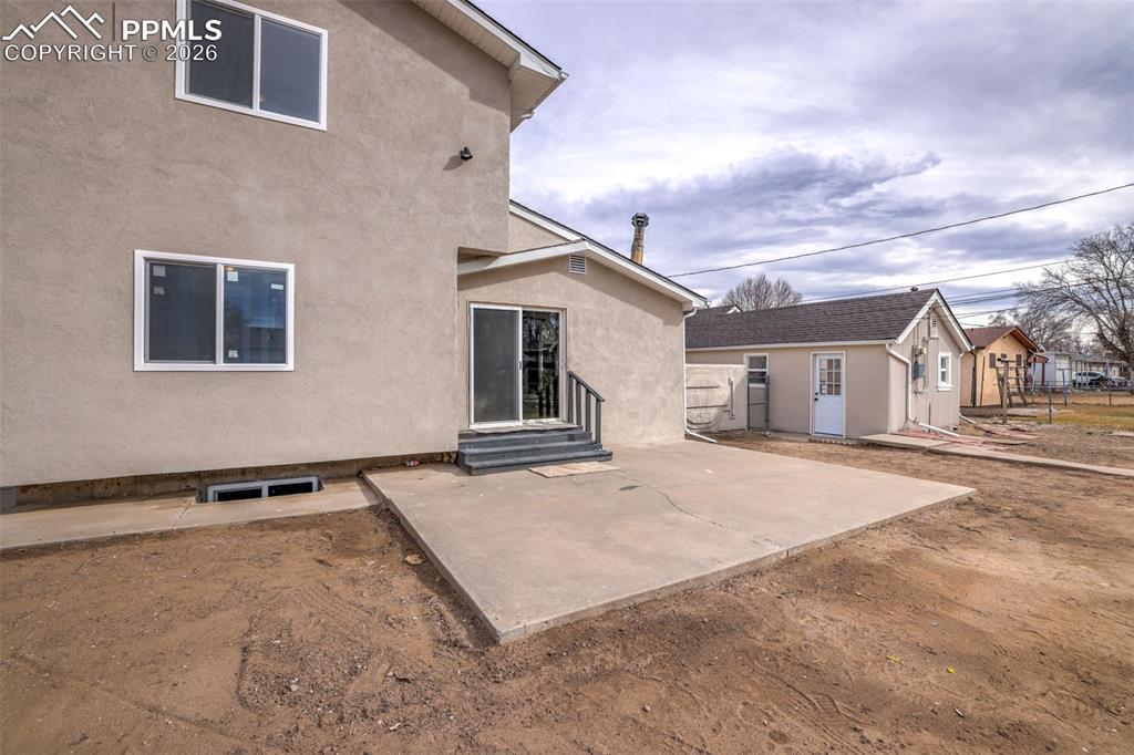 Back of house featuring a patio, stucco siding, and entry steps