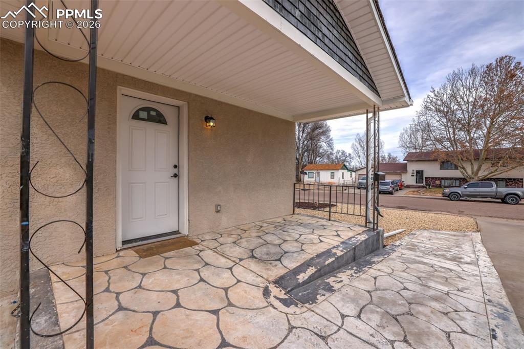Entrance to property featuring a porch and stucco siding