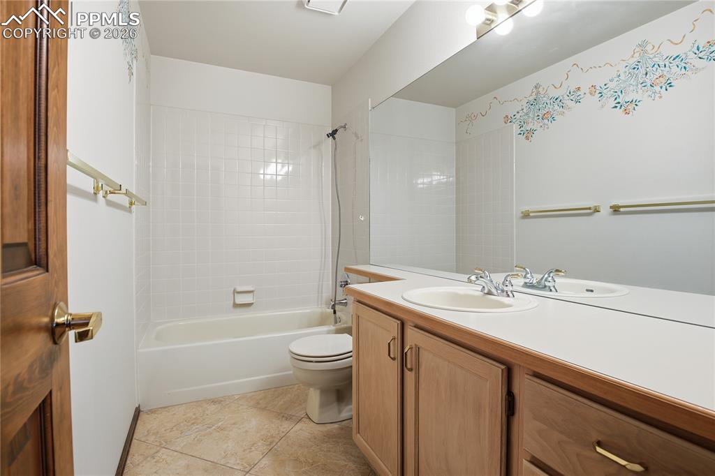 Bathroom with vanity, shower / bath combo with shower curtain, and light tile patterned flooring
