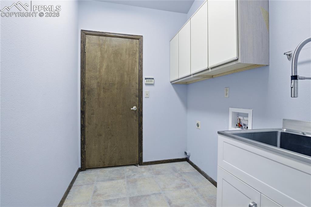 Laundry area featuring hookup for an electric dryer, cabinet space, and washer hookup